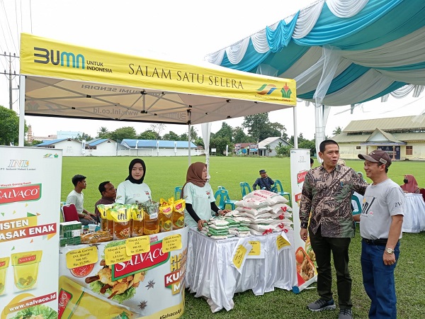 Kadisnaker Perindag Kota Binjai (baju batik) berbincang dengan distributor disela meninjau pasar murah. (Waspada/Ria Hamdani)