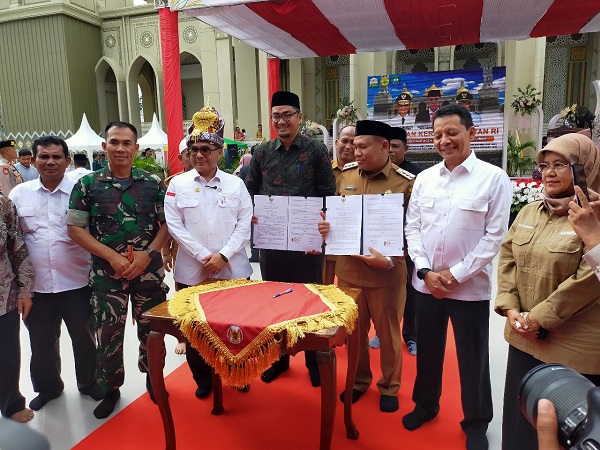 Pj Bupati Abdya Darmansah (baju dinas), Pj Bupati Aceh Singkil Martunis (kemeja batik), didampingi Wamentan Harvick dan Pj Gubernur Achmad Marzuki, memperlihatkan dokumen kerjasama antara Pemkab Abdya dengan Pemkab Aceh Singkil, terkait surplus beras, Senin (21/11). Waspada/Syafrizal