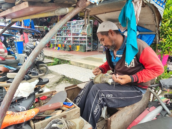 Mahyidin, salah satu tukang sol yang menempati lapak di jalan Pasar Ikan atau Blok B Kota Langsa yang tak pernah tersentuh bantuan pemerintah, Selasa (13/12). Waspada/Rapian