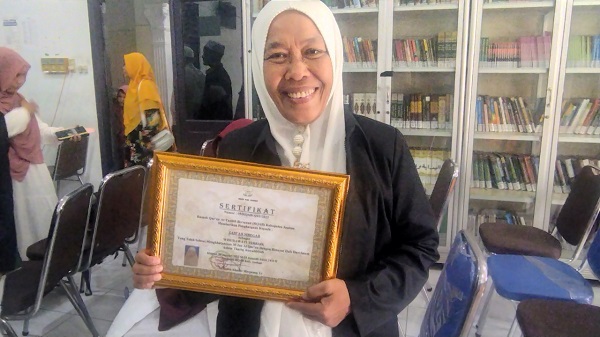 Zam'ah Siregar,56, memegang setifikat wisudawan terbaik mengkhatamkan 30 Juz Qur'an Riwayat Hafsh dari Imam 'Ashim Tahriq As Syatibiyah angkatan ke-2 dari Rumah Qur'an At Tauhid Bersanad Kisaran. Waspada/Sapriadi