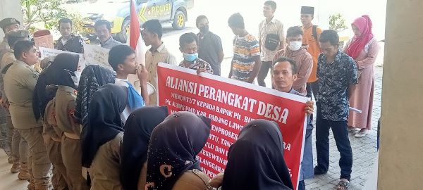 Perangkat desa dan masyarakat Kecamatan Ulu Barumun, menggelar aksi unjuk rasa meminta keadilan atas pemberhentian sepihak yang mereka alami. Kamis (13/4) (Waspada/Muhammad Satio)