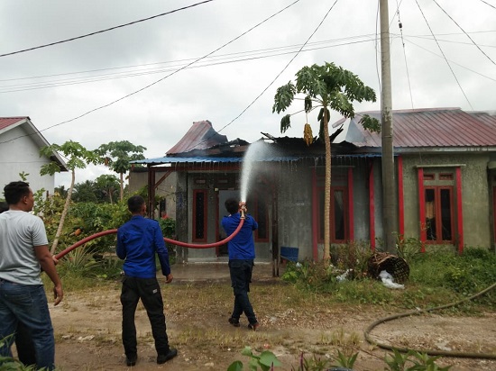 PETUGAS pemadam saat melakukan pemadaman rumah yang terbakar. (Waspada/Ist)