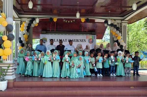 Tampak Geuchik Gampong Sungai Pauh Pusaka, Musliadi didampingi Kepala Sekolah Bunda PAUD Pusaka, Dewi Purwanti, berfoto bersama dengan anak-anak PAUD dalam wisuda, di kolam renang Vitra Tirta Raya, Sabtu (17/6). Waspada/Rapian.