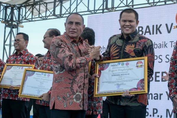 Gubernur Sumatera Utara Edy Rahmayadi menyerahkan penghargaan kepada Wabup Sergai H. Adlin Tambunan. Waspada/ist