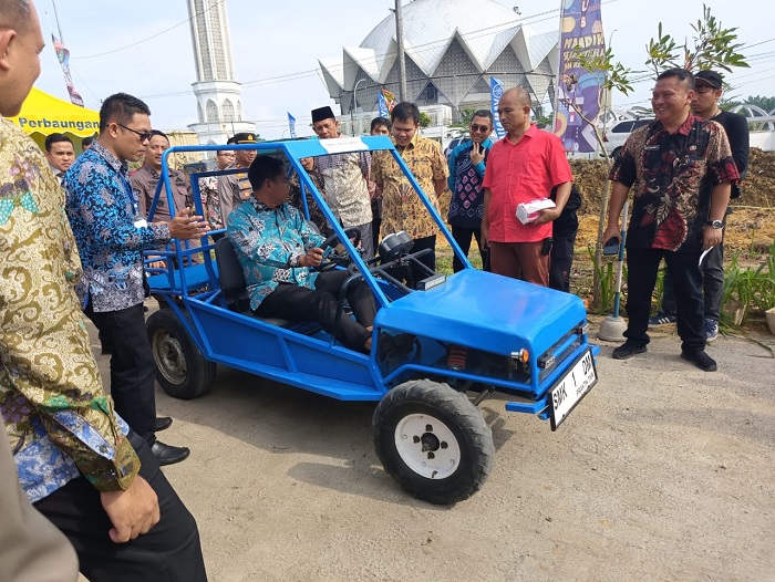 Bupati Sergai H. Darma Wijaya melakukan test drive mobil listrik karya SMK N 1 Dolokmasihul. Waspada/Darmawan