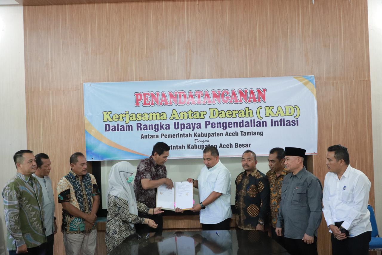 Pj Bupati Aceh Besar bersama Plh. Sekda Kabupaten Aceh Tamiang Muslizar, menunjukan berkas MoU Kerjasama Antar Daerah (KAD) dengan Pemerintah Kabupaten Aceh Tamiang dalam upaya untuk pengendalian Inflasi daerah, di Aula Kantor Bupati Aceh Tamiang, Kuala Simpang, Minggu (24/2). (Waspada/Ist)