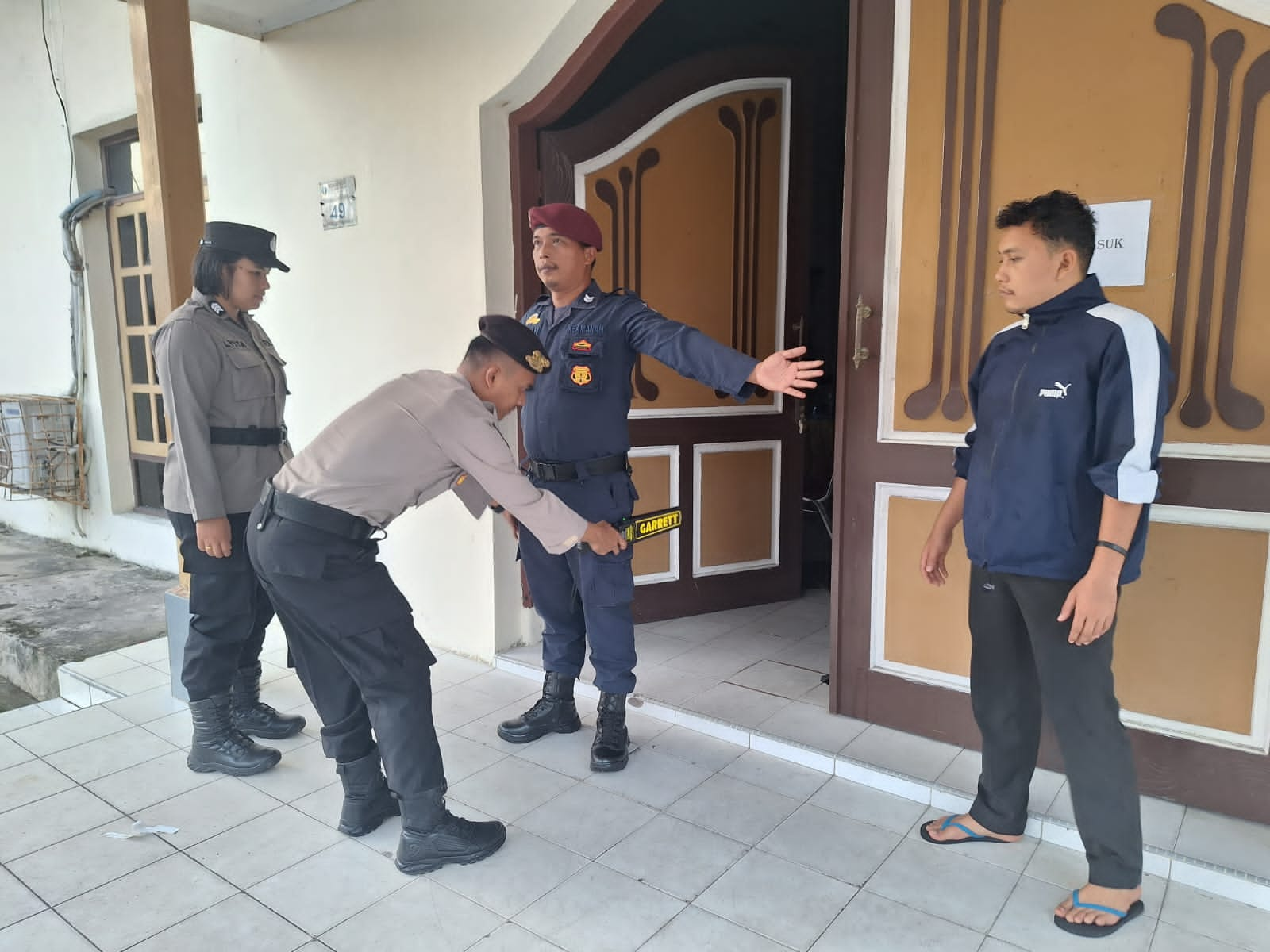 Personel Polres Sibolga memeriksa peserta Rapat Pleno Rekapitulasi Perhitungan Suara Pemilu 2024 Tingkat KPU Kota Sibolga menggunakan metal detector, Kamis (29/2). Waspada/ist