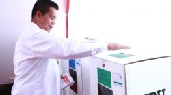 Bupati Simalungun Radiapoh H Sinaga memasukkan kertas suara ke kotak suara usai melakukan pencoblosan di TPS 026 Nagori Pematang Simalungun, Rabu (14/2).(Waspada/ist).