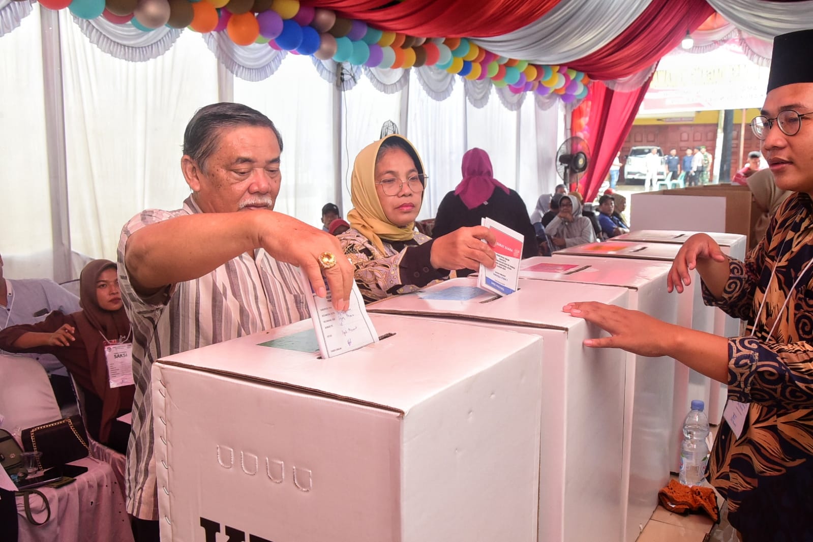 BUPATI Deliserdang HM Ali Yusuf Siregar bersama Ketua TP PKK Deliserdang Hj.Sri Pepeni MA Yusuf Siregar memasukkan surat suara kedalam kotak suara usai melakukan pencoblosan di TPS 18 Desa Dagang Kerawan Tanjungmorawa pada Pemilu serentak Tahun 2024, Rabu (14/2). (Waspada/Ist)