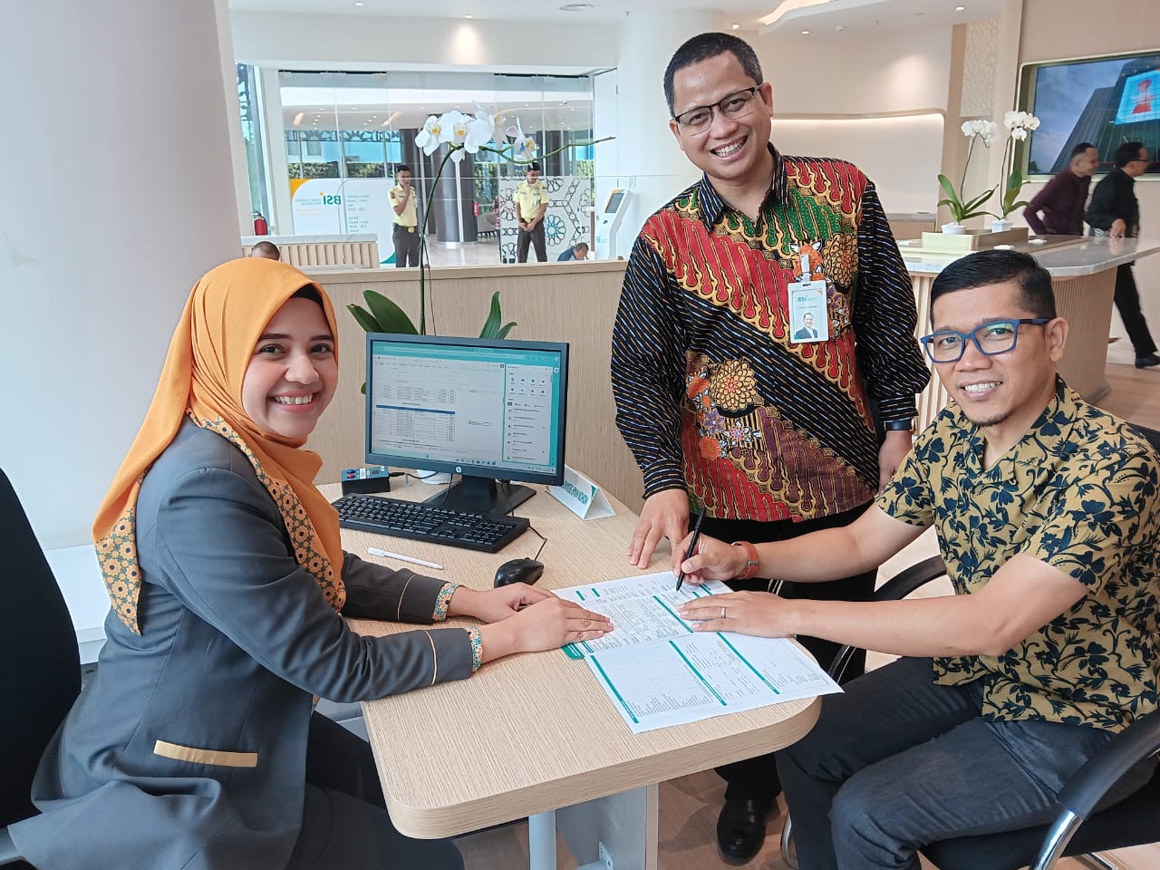 Ketua KWPSI Dosi Elfian (paling kanan) sedang membuka buku rekening tabungan di Gedung Landmark BSI Aceh, serta didampingi Regional CEO BSI Aceh Wisnu Sunandar (tengah), Banda Aceh, Selasa (19/3). (Waspada/Ist)