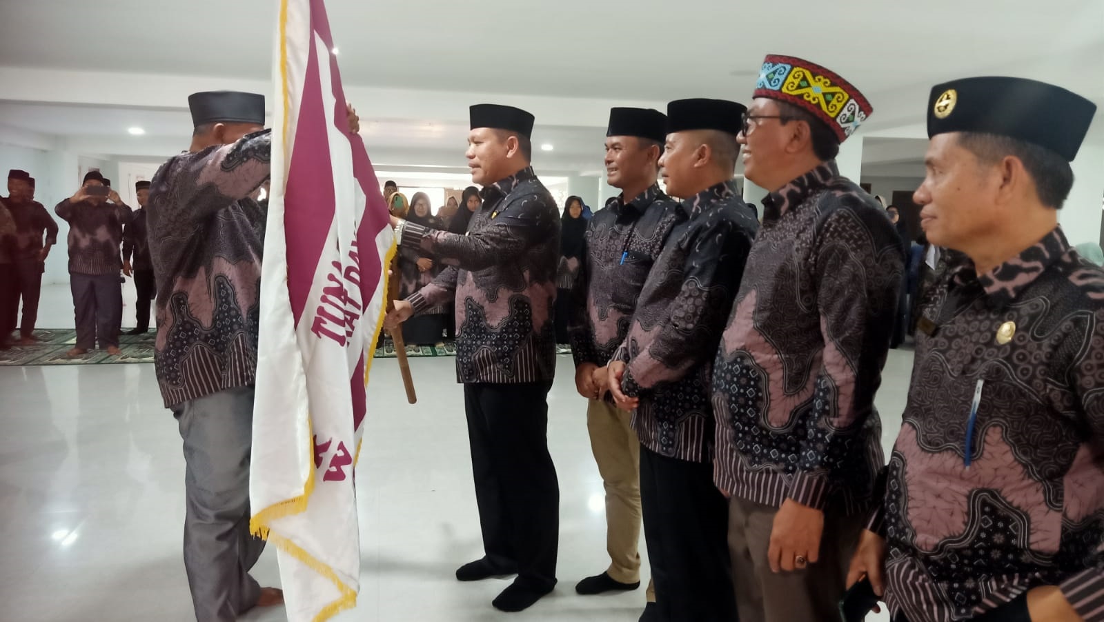 Pj Bupati Abdya Darmansah (kanan), menyerahkan bendara pataka kepada kontingen MTR Pramuka Abdya, yang akan diberangkatkan ke Banda Aceh. Kegiatan berlangsung di aula Mesjid Agung Baitul Ghafur, Blangpidie. Kamis (21/3).Waspada/Syafrizal