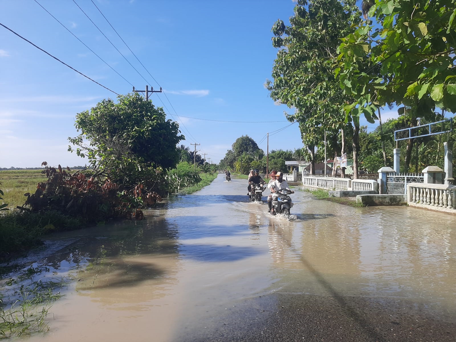 Kondisi jalan P.Bandar - Kerasaan, persisnya di Nagori Purwodadi atau depan sekolah SD/SMP Margautama, digenangi banjir menyusul hujan deras yang melanda daerah itu. Foto direkam Jumat (17/5).(Waspada/Hasuna Damanik).