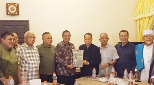 MANTAN Gubernur Sumut Tengku Erry Nuradi menyerahkan buku 100 Tokoh Melayu Nusantara kepada Rektor UMSU Agussani saat tokoh-tokoh Melayu Sumut berkumpul di Aobi Café Medan, Jumat (24/5) malam. Waspada/Ist