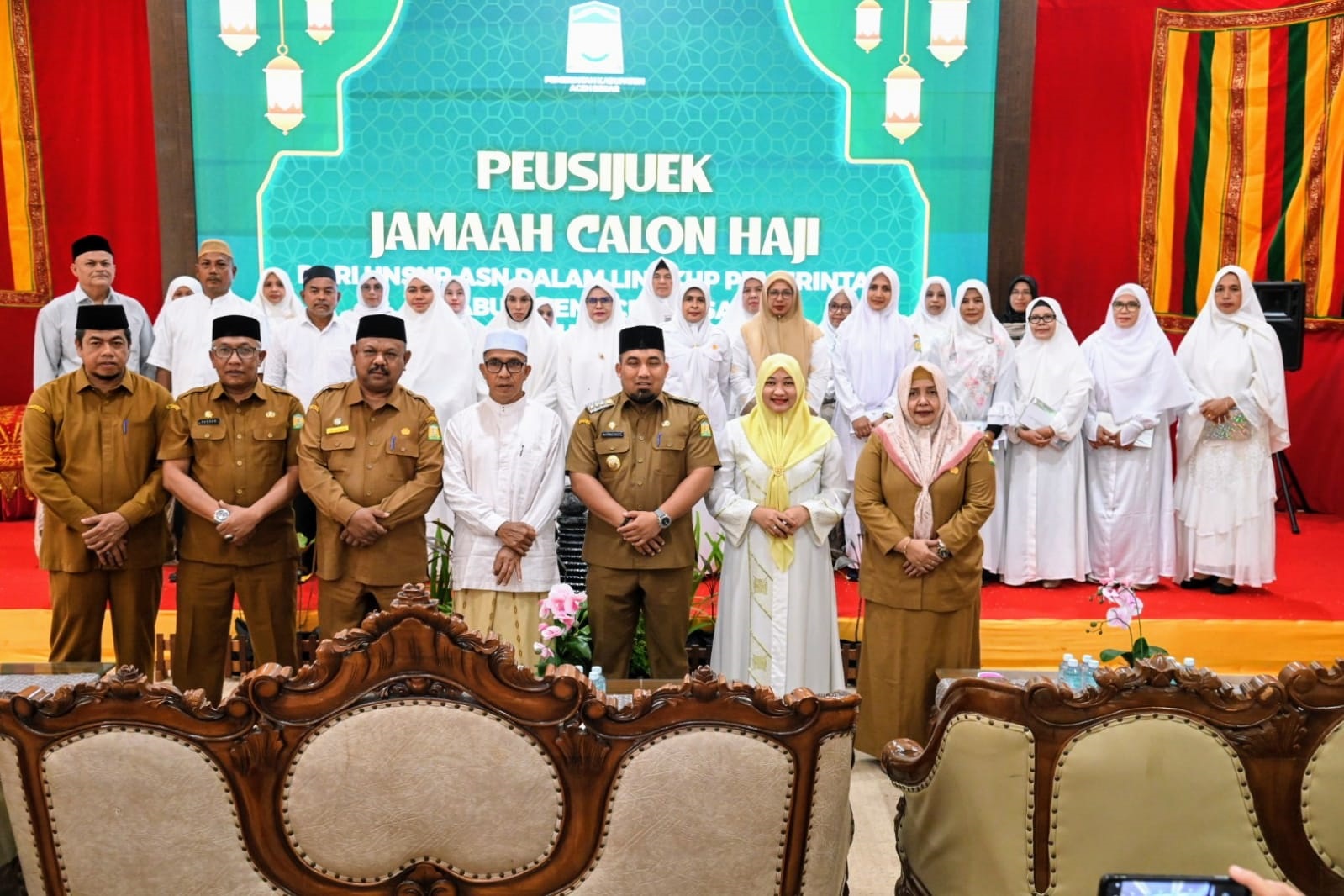 Pj Bupati Aceh Besar, Muhammad Iswanto dan Pj Ketua TP PKK Aceh Besar Cut Rezky Handayani foto bersama seusai acara peusijuk Jamaah Calon Haji unsur ASN Pemkab Aceh Besar Tahun 2024 di Meuligo Bupati Aceh Besar, Kota Jantho, Senin (27/5). (Waspada/Ist)