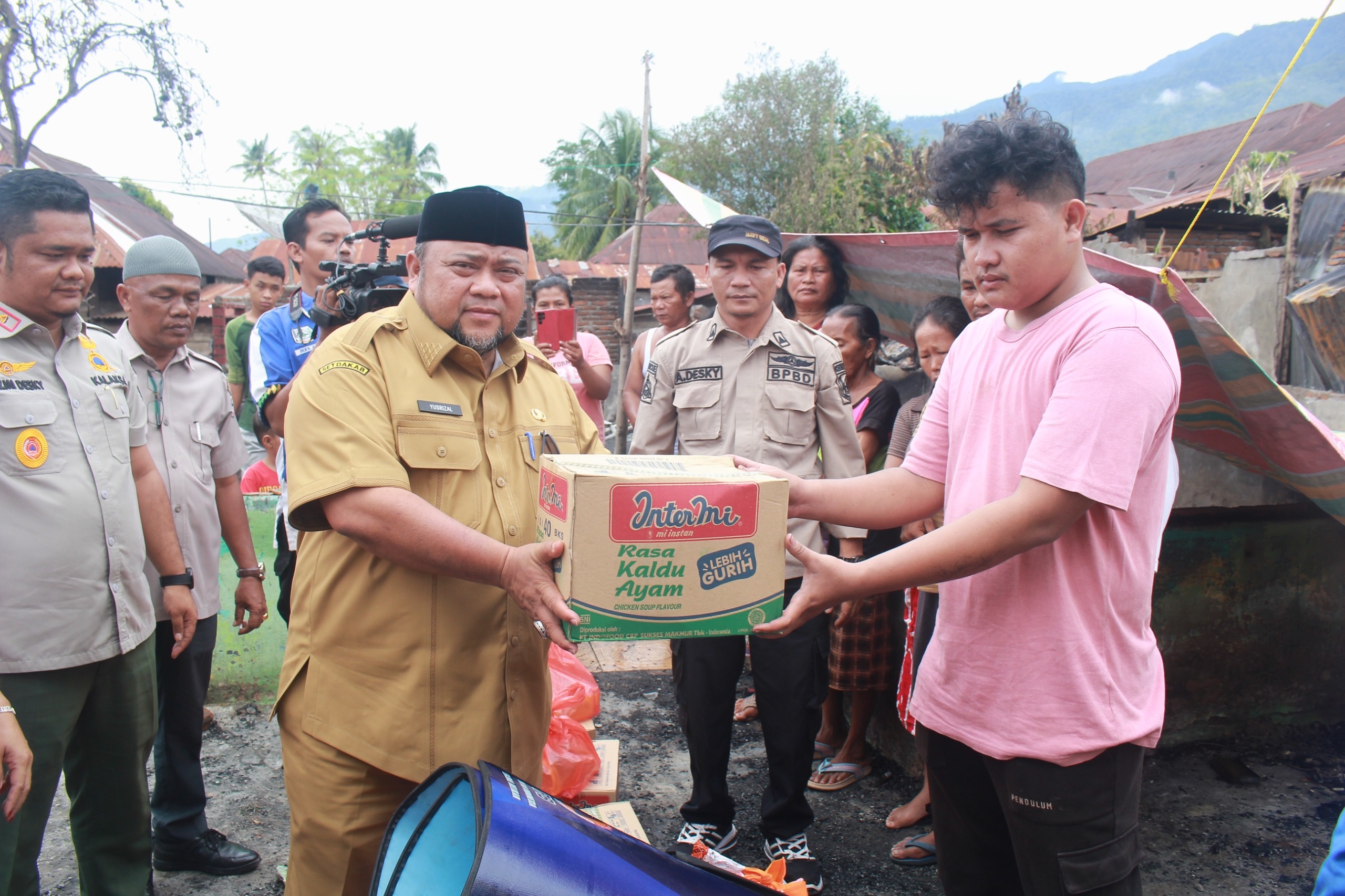 Pj Sekda Yusrizal saat menyerahkan bantuan masa panik. Waspada/Seh Muhammad Amin