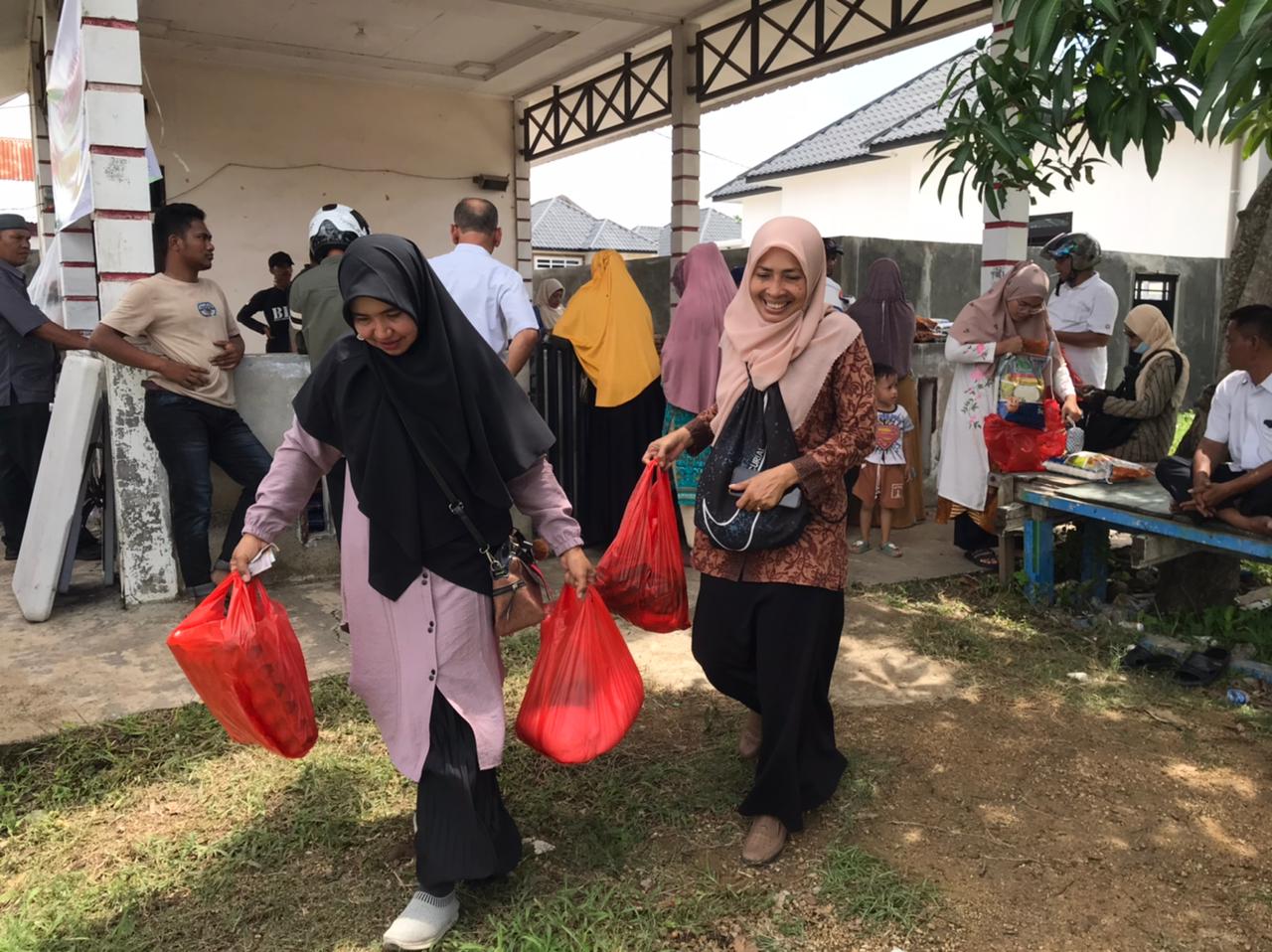 Ibu-ibu membawa pulang sembako murah pada pergelaran pasar yang digelar pada halaman Masjdi Gampong Baet, Kecamatan Baitussalam, Aceh Besar, Rabu (22/5). (Waspada/Ist)