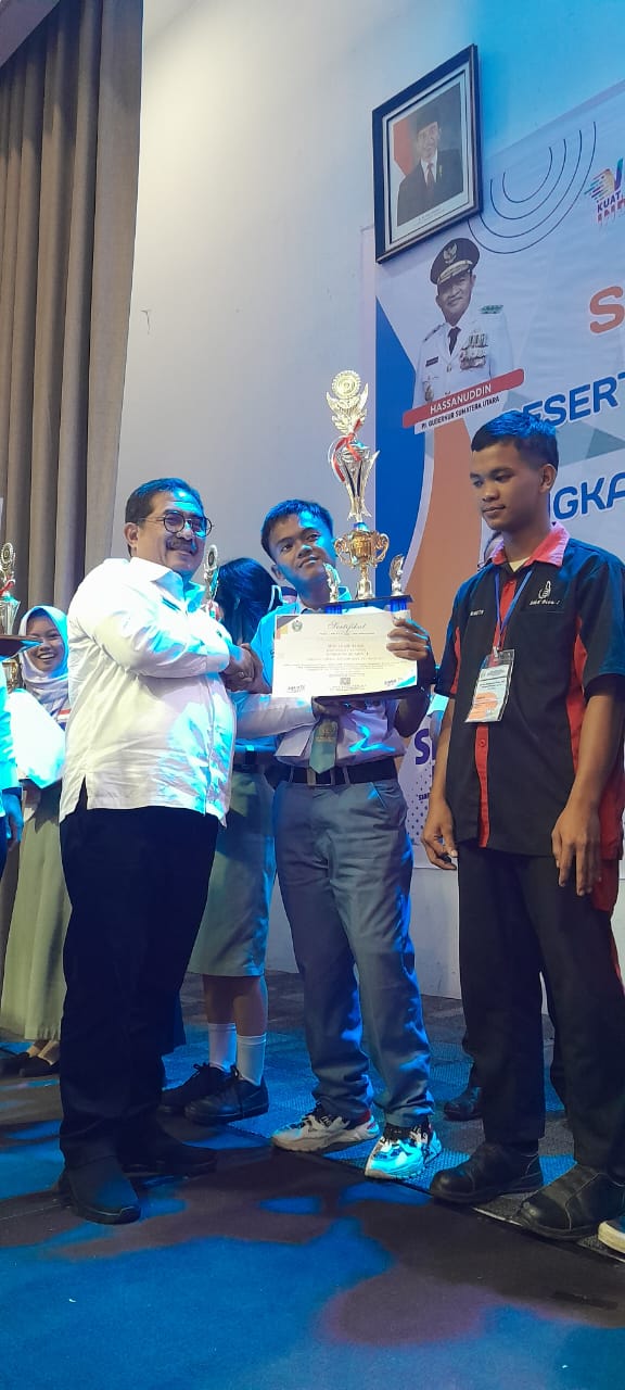 Nur Ilham Habibi menerima trophy Juara 1 LKS tingkat Provinsi Sumut dari Kepala Dinas Pendidikan Povsu Ir. Abdul Haris Lubis, M.Si.(Waspada/ist)