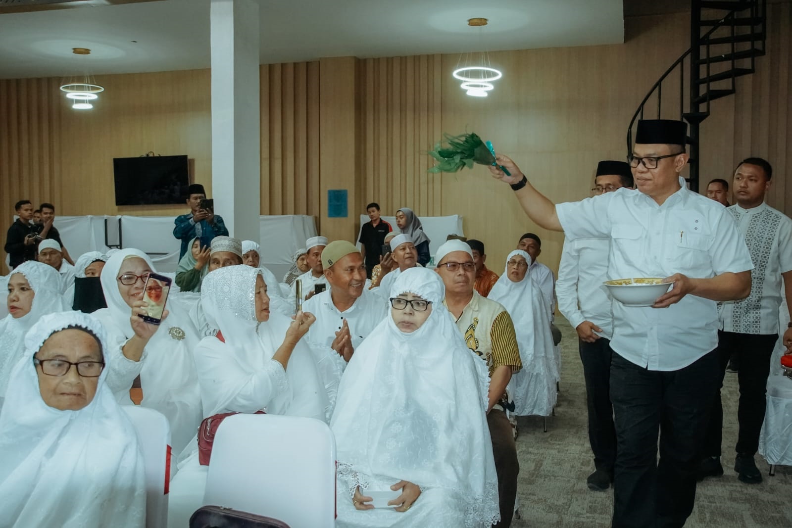   JALANNYA acara tepung tawar jamaah Calhaj Kabupaten Batubara yang tergabung dalam Kloter 11 melalui Bandara KNIA.Waspada/Ist