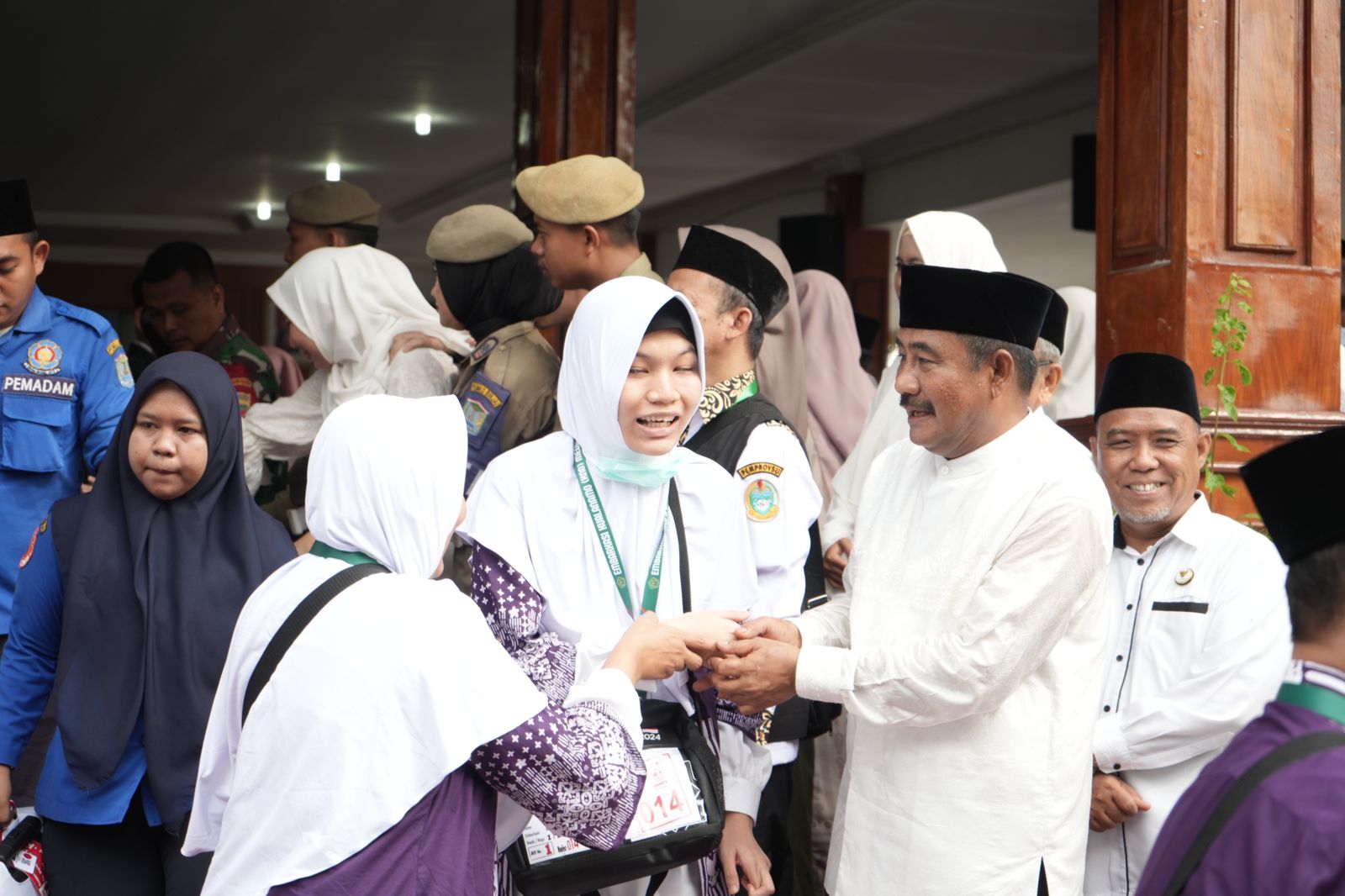 Wali Kota Binjai Drs H Amir Hamzah, MAP menyalami salah seorang calon hajah yang akan berangkat ke tanah suci.(Waspada/Ist).