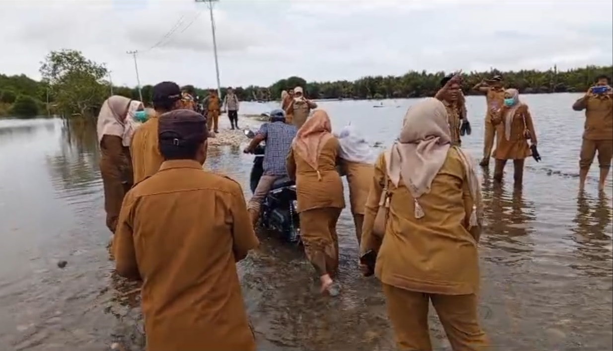 Masyarakat bersama para PNS dan pegawai honor di Kecamatan Singkil dan Kuala Baru, mendorong kendaraan yang melintas, saat menggelar aksi di jalan yang terendam banjir, Senin (20/5/2024). WASPADA/Ariefh