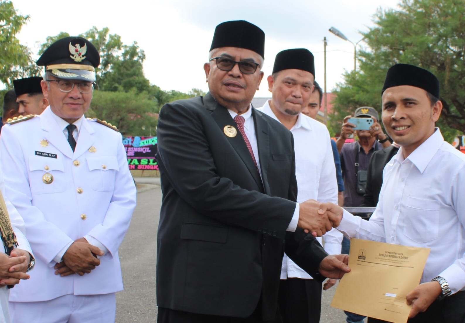 Pj Gubernur Aceh H Bustami Hamzah didampingi Pj Bupati Drs Azmi saat menyerahkan SK Guru Dayah di Perbatasan Kecamatan Danau Paris, pada momen HUT ke-25 Aceh Singkil. WASPADA/Ariefh