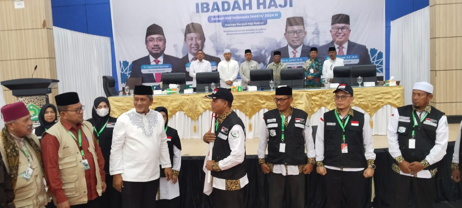 Pj. Bupati Aceh Utara diwakili Pj Sekda usai menyerahkan bendera Kloter 02 kepada Ketua Kloter (TPHI) di Aula Jeddah Asrama Haji Banda Aceh, Jumat (31/05/24). (Waspada/T.Mansursyah)