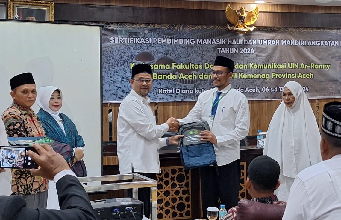 Warek I UIN Ar Raniry Banda Aceh, Prof Dr Yasir Yusuf, didampingi Dekan Fakultas Dakwah dan Komunikasi, Prof Dr. Kusmawati Hatta, dan Kabid PHU Kanwil Kemenag Aceh, Drs H Arijal, MSi, menyerahkan atribut di sela-sela Pembukaan Sertifikasi Manasik Haji dan Umrah Mandiri Angkatan III di Banda Aceh, Senin (6/5) malam. Waspada/st.