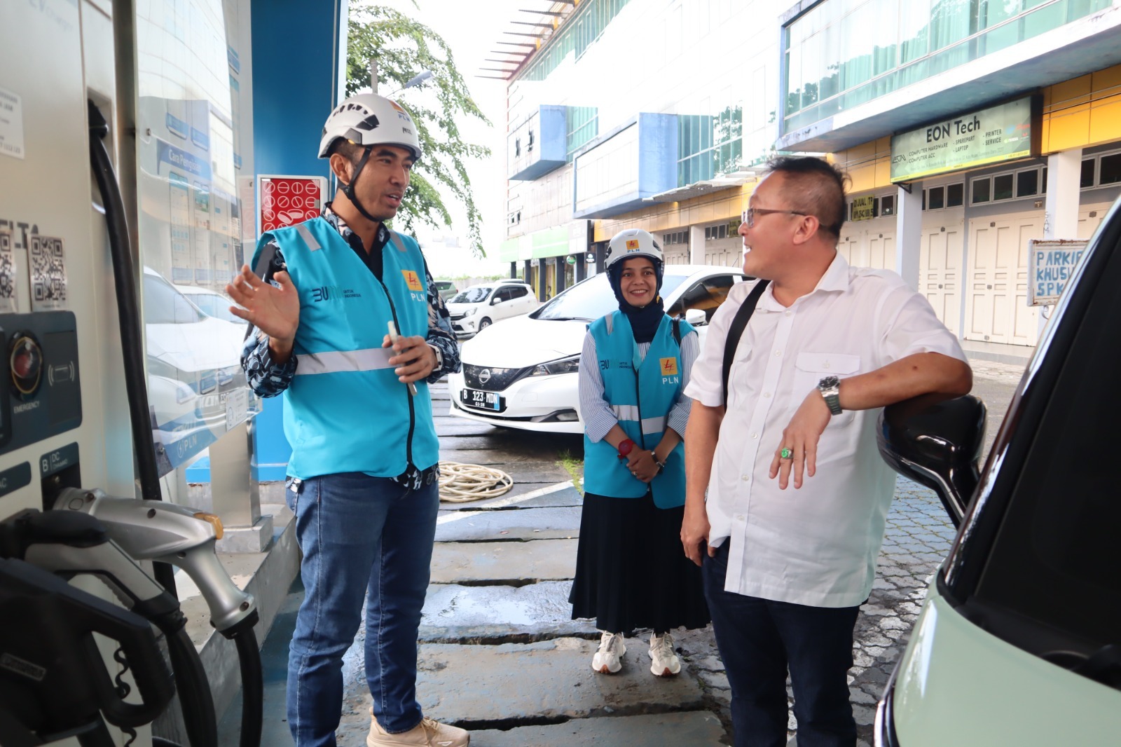 Manager PLN UP3 Medan Ricki Yakop (kiri) bersama Assistant Manager Pemasaran Emmy Sinaga (tengah) sedang menjelaskan keunggulan pengisian daya melalui SPKLU kepada Tonny pengguna kendaraaan listrik (kanan) di SKPLU City View, Sabtu (15/6).