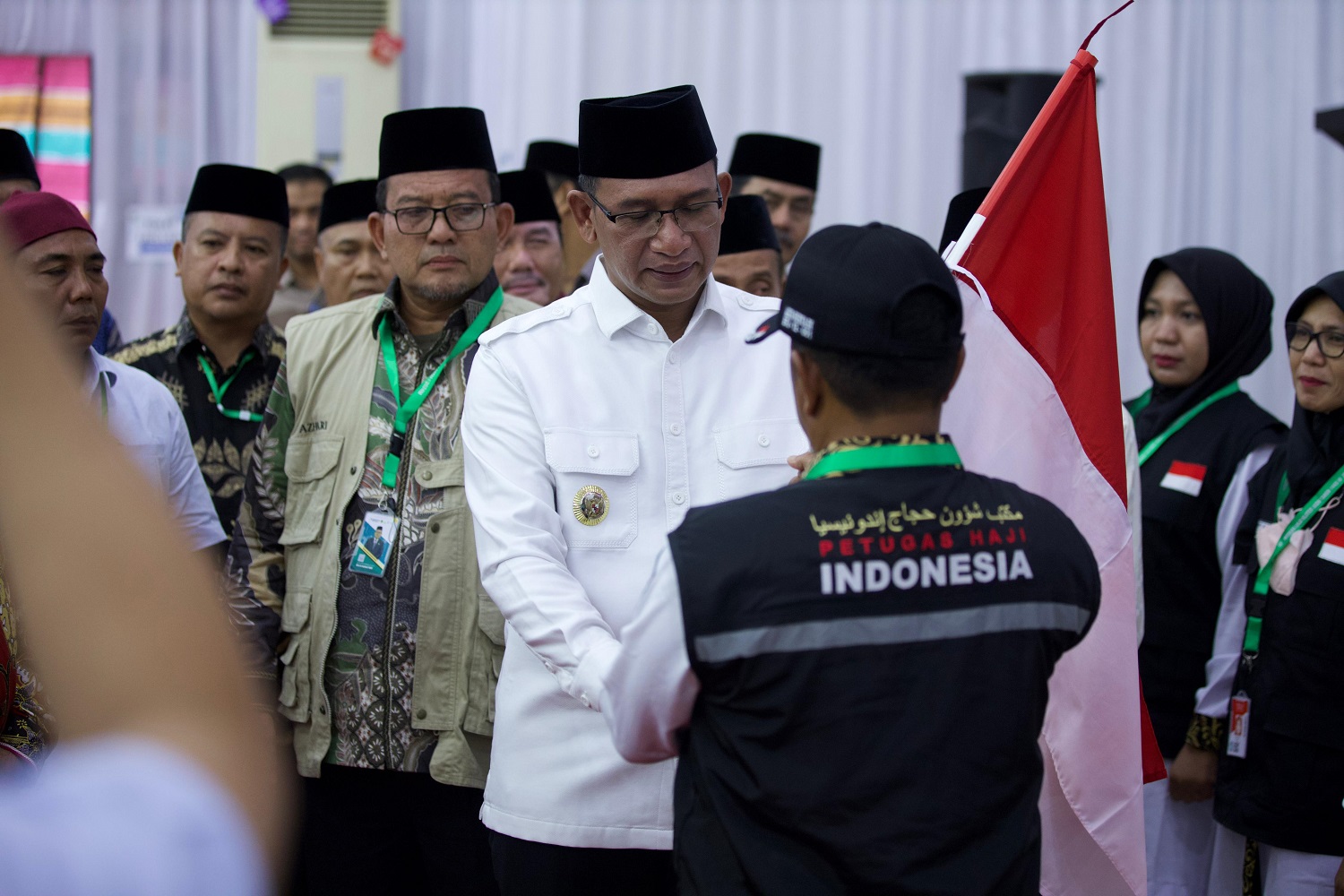 Pj Bupati Aceh Selatan Cut Syazalisma menyerahkan bendera merah putih kepada ketua kloter pelangi (kloter 12) usai melepas di Aula Jeddah Asrama Haji Banda Aceh, Minggu (09/06/24) sore.(Waspada/T.Mansursyah)