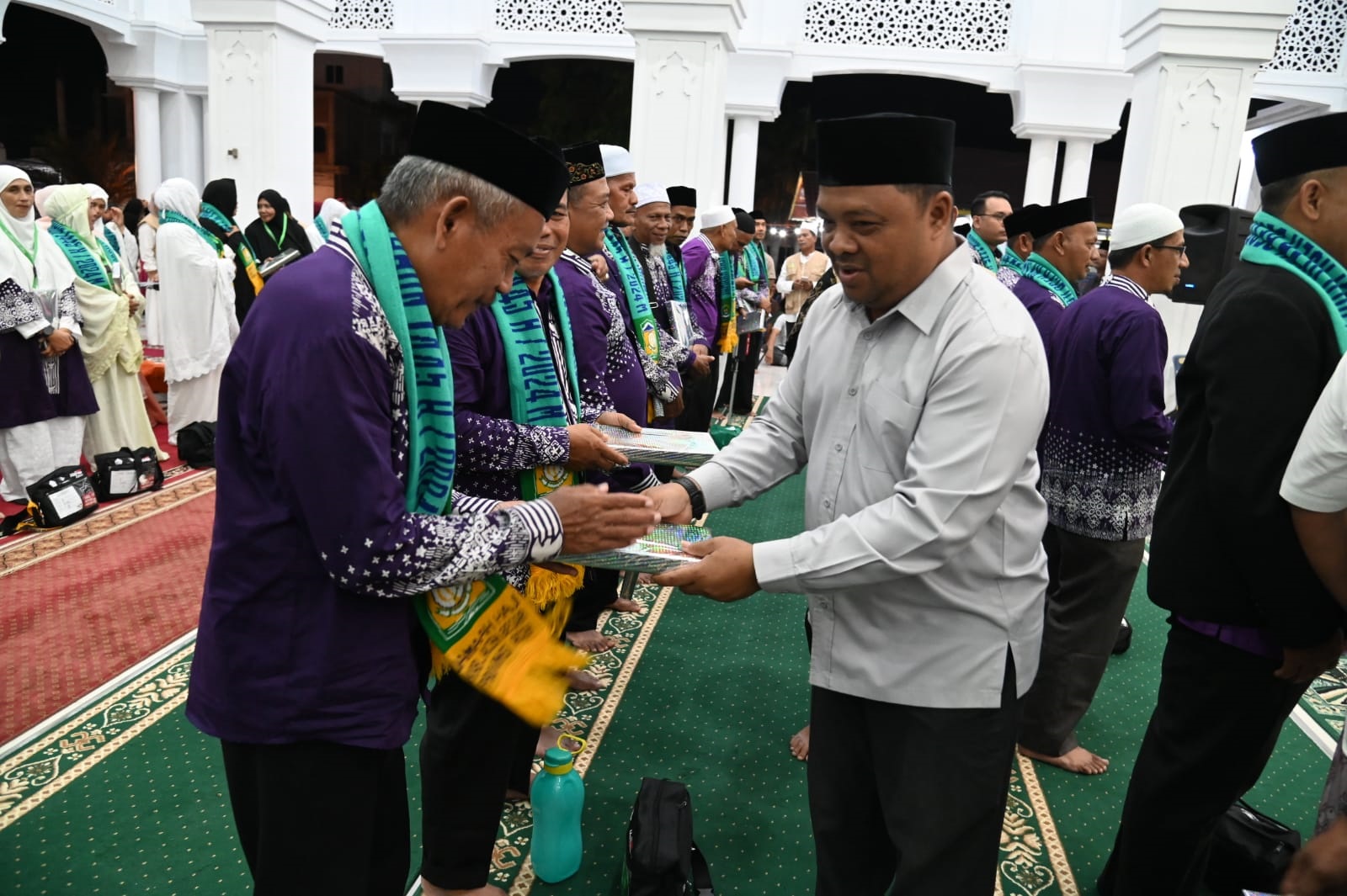 Sekdakab Aceh Besar, Sulaimi memberikan bingkisan dan ucapan selamat kepada Jamaah Calon Haji Kabupaten Aceh Besar Tahun 2024 di Masjid Ath-Thahirah Gampong Lamcot, Kecamatan Darul Imarah, Aceh Besar, Minggu (2/6) malam. (Waspada/Ist)