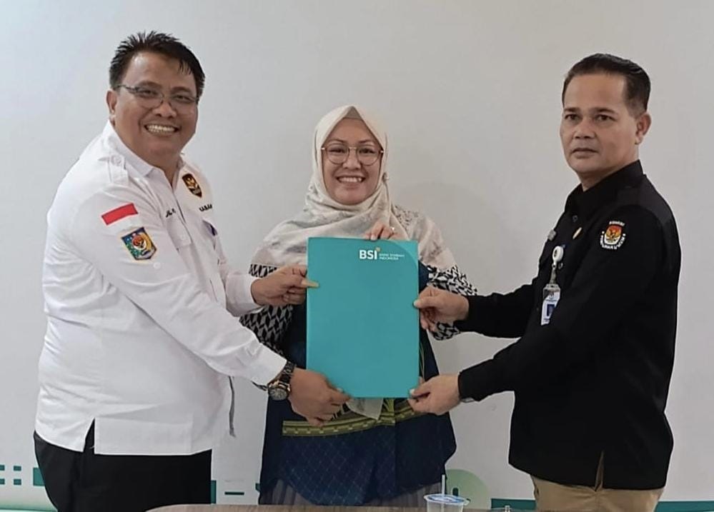 Kaban Kesbangpol Zulhadisyah, saat menyerahkan berita acara dana hibah Pilkada tahun 2024 untuk Kota Langsa tahap II sebesar 60 persen kepada Sekretaris KIP Kota Langsa, H Dahlan yang disaksikan Pimpinan BSI KCP I Langsa, Cut Lini, di ruang rapat BSI Langsa, Rabu (12/6) petang. Waspada/Ist