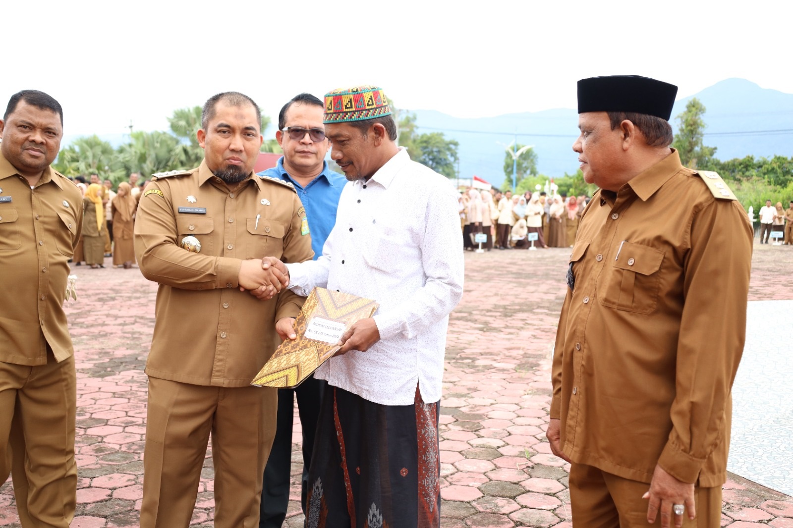 Pj Bupati Aceh Besar Muhammad Iswanto menyerahkan Surat Keputusan Pengakuan dan Perlindungan Masyarakat Hukum Adat kepada perwakilan imuem mukim di halaman Kantor Bupati Aceh Besar, Kota Jantho, Senin (3/6). (Waspada/Ist)