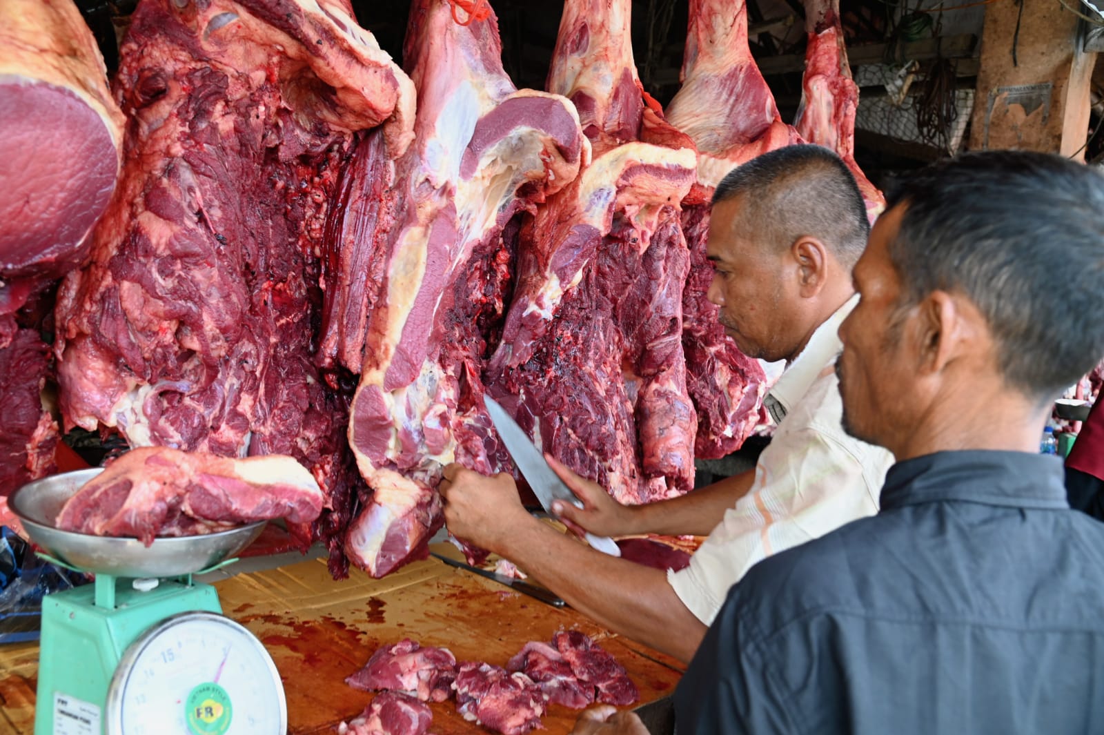 Seorang pedagang sedang memotong daging untuk para pembeli, di Pasar Induk Lambaro, Kecamatan Ingin Jaya, Aceh Besar, Minggu (16/6). (Waspada/Ist)