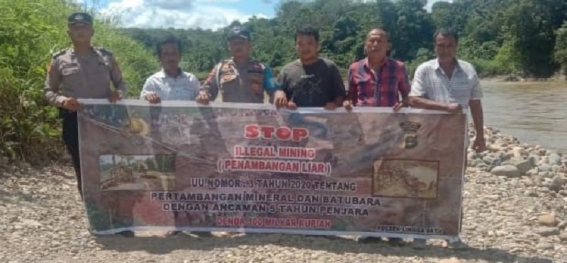 Polsek Lingga Bayu memasang spanduk imbauan Stop Illegal Mining di Sungai Batang Natal. (Waspada/ist)