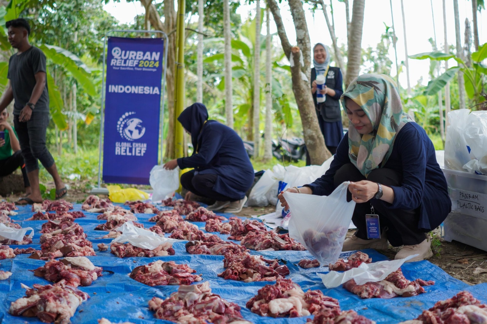 Seorang relawan GER sedang membungkus daging kurban untuk dibagikan kepada kaum duafa. Waspada/Munawardi