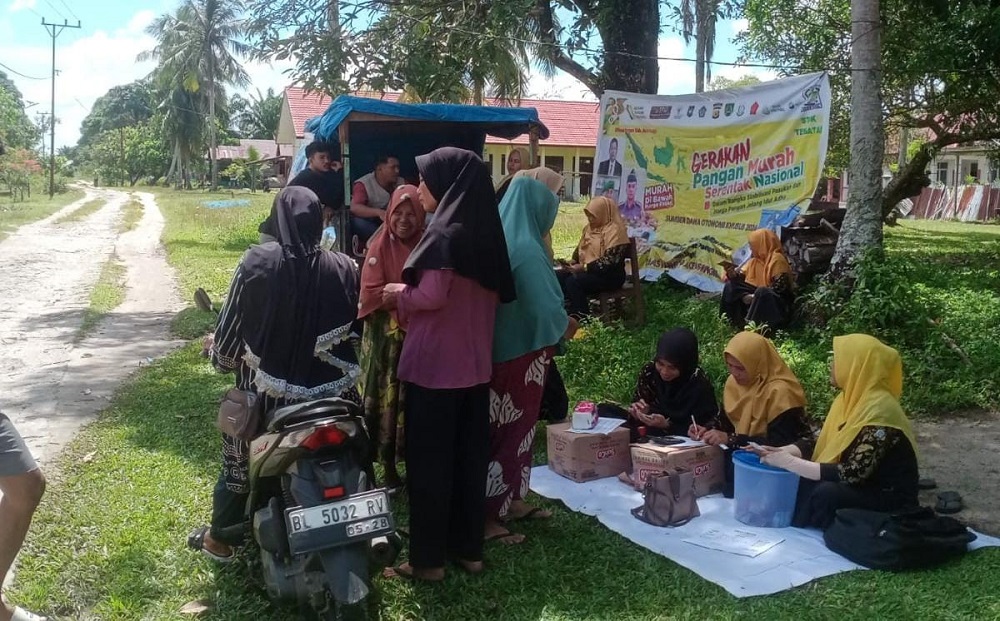 Tim GPM saat melayani pembelian pangan murah dari atas mobil bak terbuka, persis di tepi ruas jalan Provinsi Singkil-Kuala Baru di Desa Kayu Menang, Senin (24/6). WASPADA/Dinas Pangan.