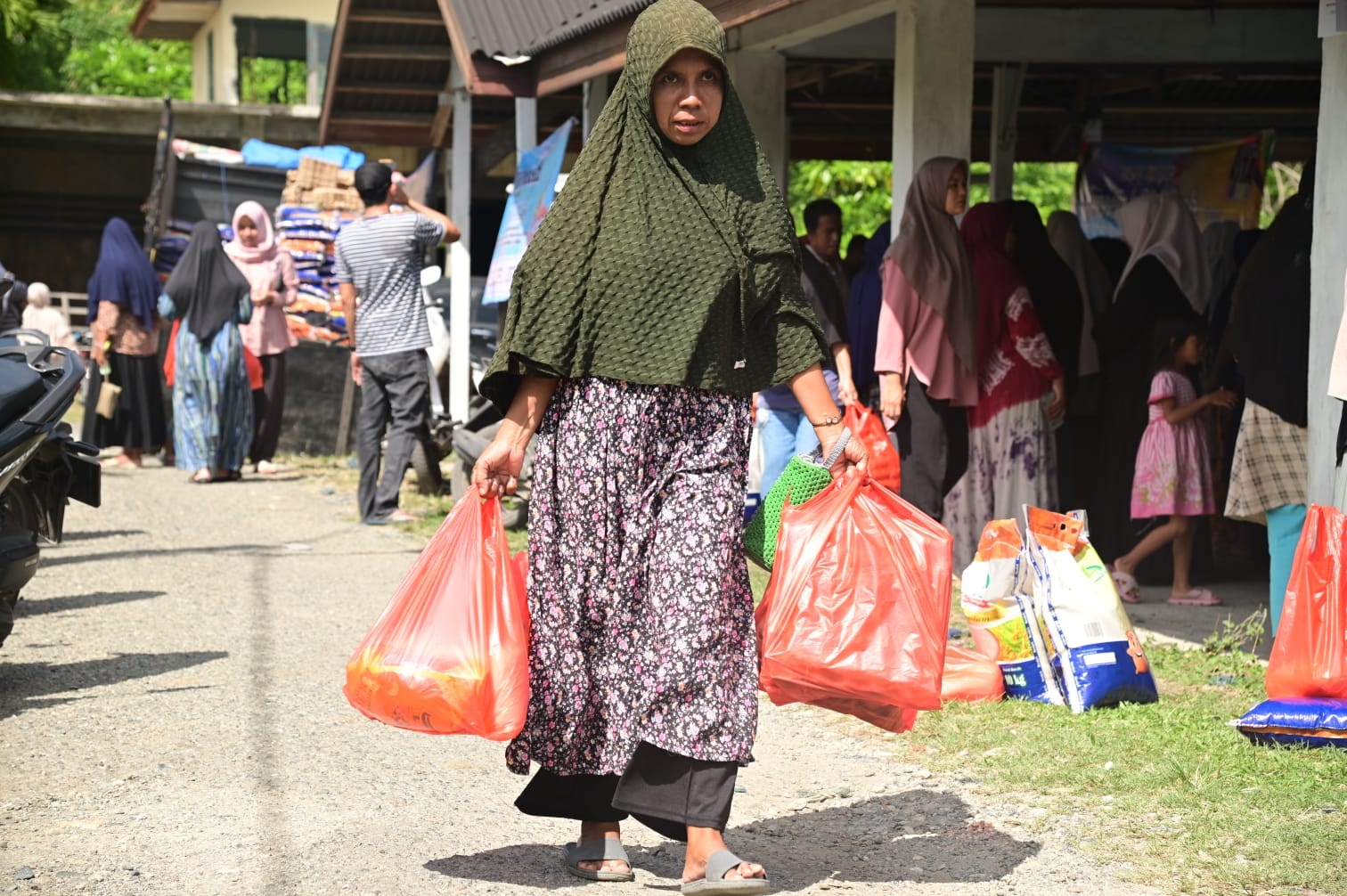 Warga Lamteungoh sedang membawa pulang belanjaannya usai membeli pada pasar khusus Pemkab Aceh Besar di Komplek TPI Gampong Lamteungoh, Kecamatan Peukan Bada, Rabu (5/6/). (Waspada/Ist)