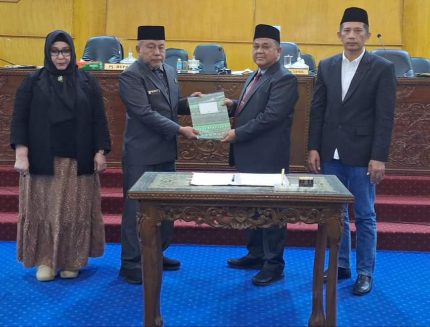 Pj. Bupati Aceh Tamiang Asra dan Ketua DPRK Aceh Tamiang Suprianto menunjukkan berkas tentang pertanggungjawaban pelaksanaan APBK Aceh Tamiang Tahun Anggaran 2023 yang turut disaksikan Wakil Ketua DPRK Aceh Tamiang, Muhammad Nur dan Sekretaris DPRK setempat, Rulina Rita, Selasa (2/7). Waspada/ Muhammad Hanafiah