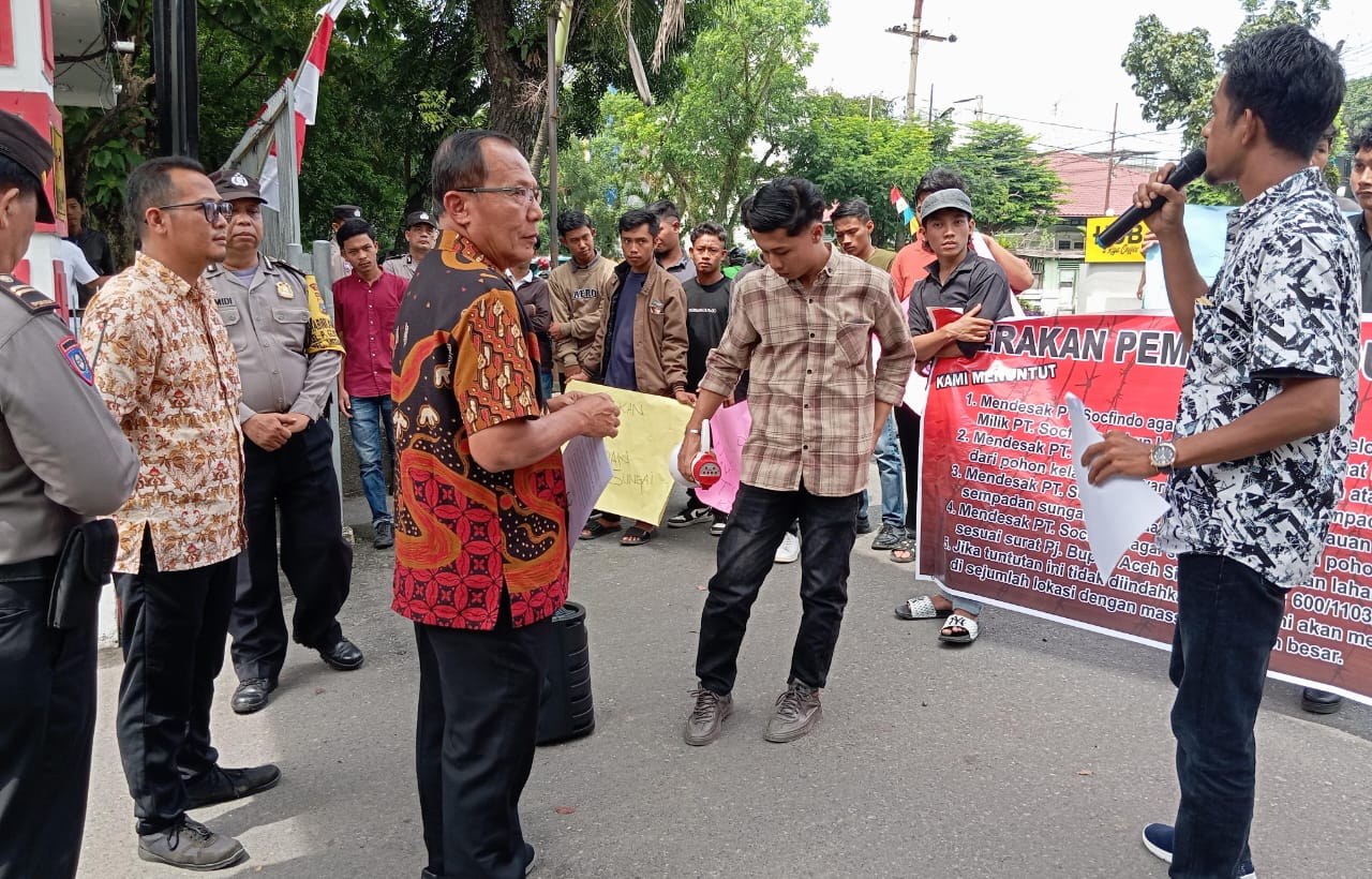 Gabungan mahasiswa dan pemuda Aceh Singkil dengan membentangkan spanduk tuntutan, saat berorasi di hadapan Kabag Umum PT Socfindo Medan, Jumat (12/7/) kemarin. WASPADA/Ariefh