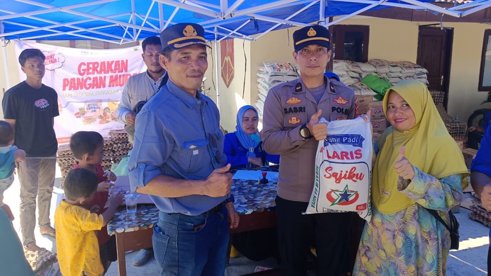 Kapolsek Ipda M Sabri didampingi Kabid Distribusi Cadangan Pangan Achyaruddin menyerahkan paket sembako kepada masyarakat, di Mapolsek Gunung Meriah, Selasa (2/7). WASPADA/Ist