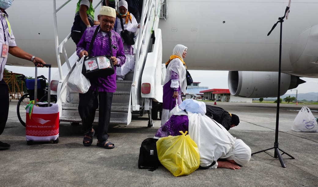 Jamaah terakhir embarkasi Aceh (kloter 12) tampak sujud syukur usai tiba di Bandara SIM Blang Bintang, Aceh Besar, Senin (22/07/24).(Waspada/Ist)