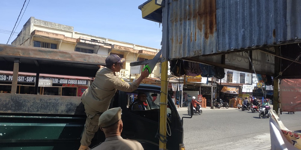 Petugas Satpol PP dan WH Aceh Besar melakukan penertiban di Jalan Mata Ie Keutapang, Kecamatan Darul Imarah, Aceh Besar, Kamis (25/7). (Waspada/Ist)