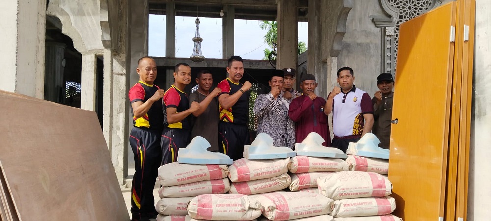 Danki 2 Batalyon B Pelopor AKP Muhammad Rizaldi dan personelnya saat menyerahkan bantuan berupa material semen, besi dan pipa paralon untuk pembangunan MCK, di Masjid Nurul Ikhlas, Gampong Aramiyah Kecamatan Birem Bayeun, Kabupaten Aceh Timur, Jumat (26/7). Waspada/Rapian