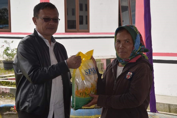 ASISTEN Perekonomian dan Pembangunan Setdakab, Martogi Purba memberikan beras secara simbolis usai membuka giat GPM di Lintongnihuta. Waspada/Ist