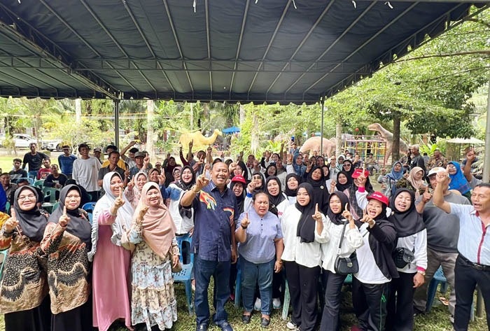 Calon Bupati Syah Afandin foto bersama masyarakat di Taman Wisata Andak Aniel di Desa Pantai Gemi, Stabat. Waspada/Ist