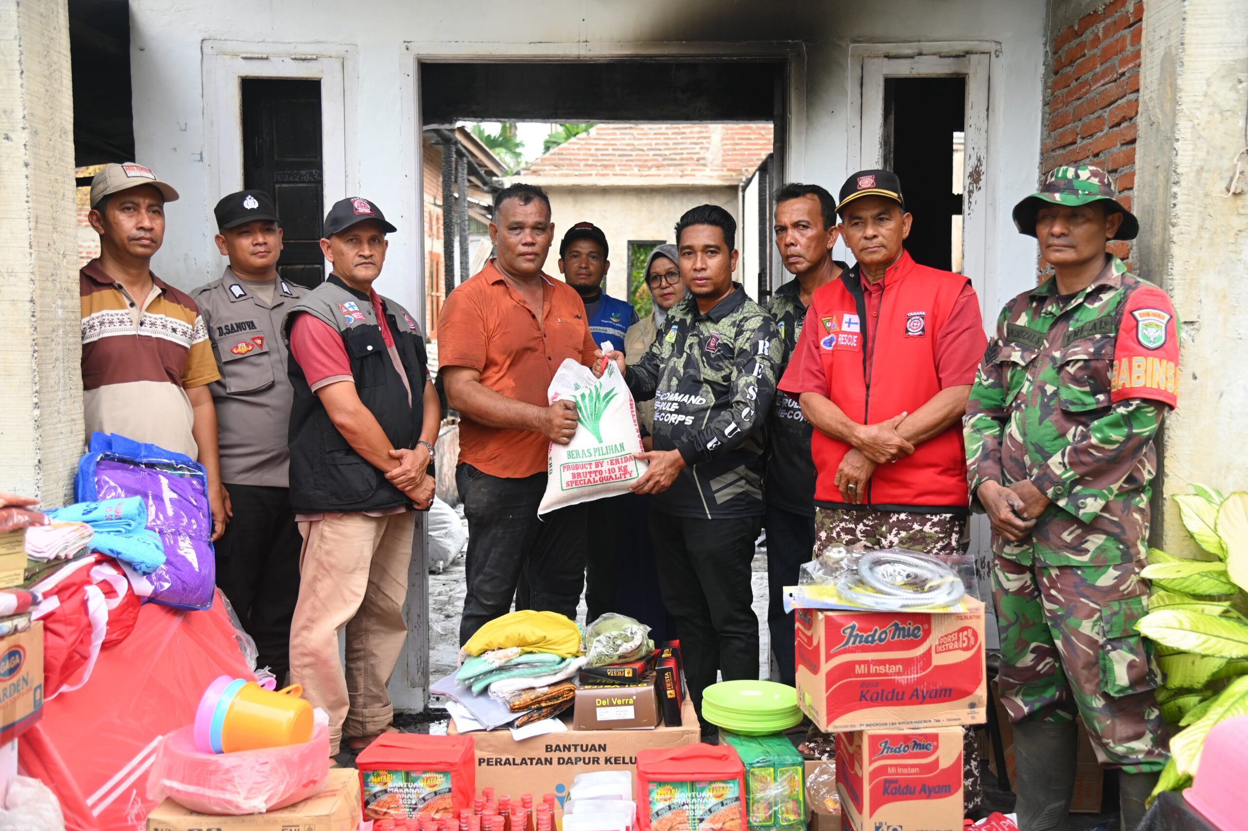 Plt Kadis Sosial Aceh Besar Aulia Rahman, didampingi unsur Forkopimcam Indrapuri, perangkat gampong, dan pilar-pilar sosial, menyerahkan bantuan masa panik, kepada Muhammad Yatim, kepala keluarga korban kebakaran rumah, di Gampong Ulee Ue, Kecamatan Indrapuri, Aceh Besar, Sabtu (14/12). (Waspada/Ist)