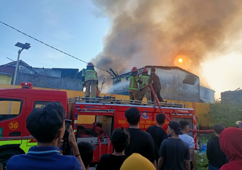 PETUGAS pemadam kebakaran berupaya memadamkan api yang membakar 16 di di Jl. Kemiri I, Kel. Sudirejo II, Medan Kota, Minggu (8/12/2024). Waspada/gito ap