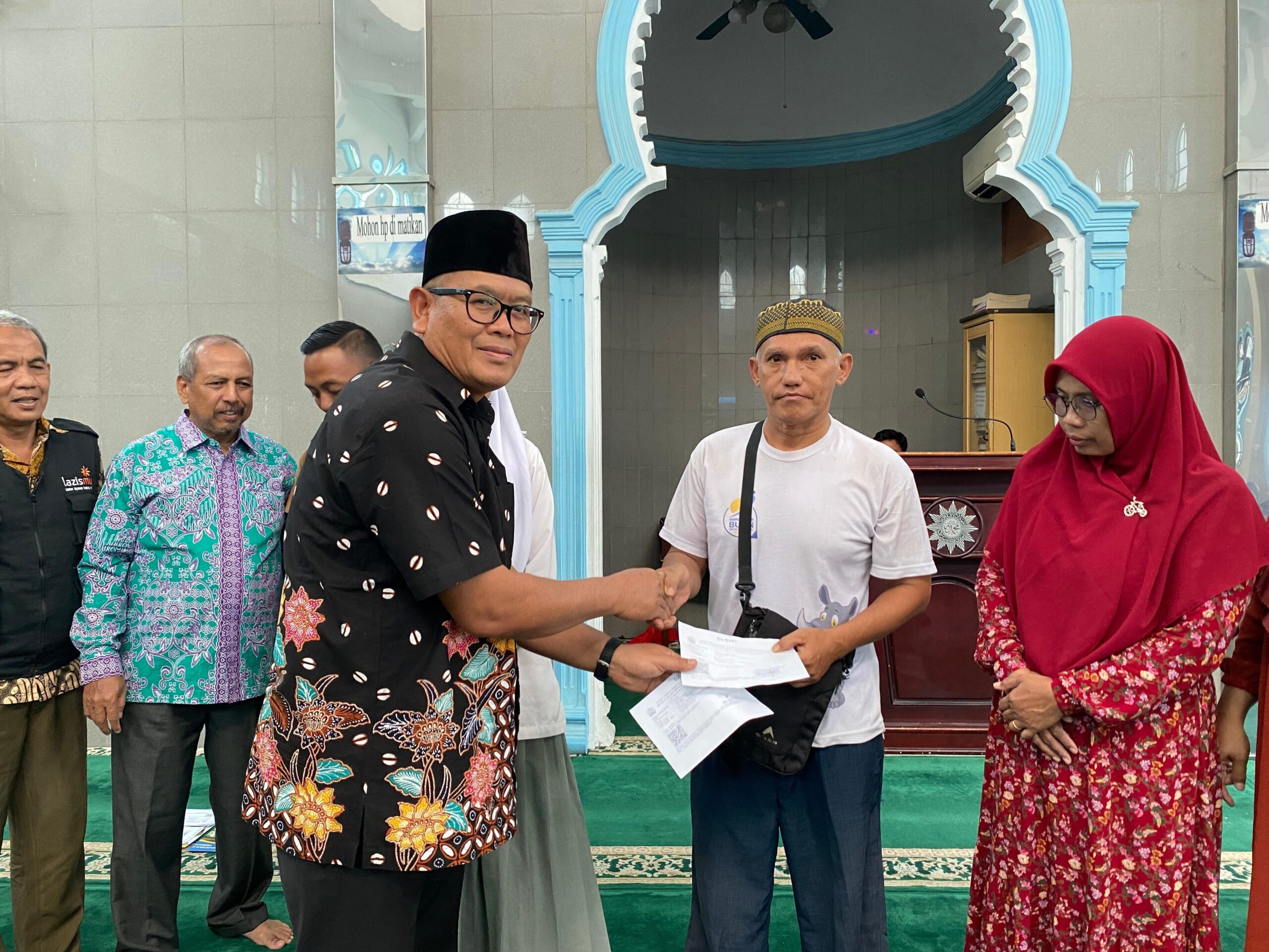 Majelis Dikdasmen PCM Muhammadiyah Tanjungsari Drs.Lilik, M.AP didampingi Kepala SMA Muhammadiyah Tanjungsari Susilawati, S. Pd, M. Psi menyerahkan bantuan Binpres kepada orangtua siswa. Waspada/Ist