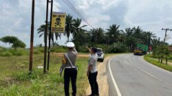 Kanit Regident Sat Lantas Polres Labusel, Ipda. M. L. Tobing saat memasang rambu peringatan di ruas Jalinsum jurusan Kotapinang-Gunung Tua, yang rawan kecelakaan lalu lintas, Jumat (14/2/2025). Waspada/Deni Daulay/