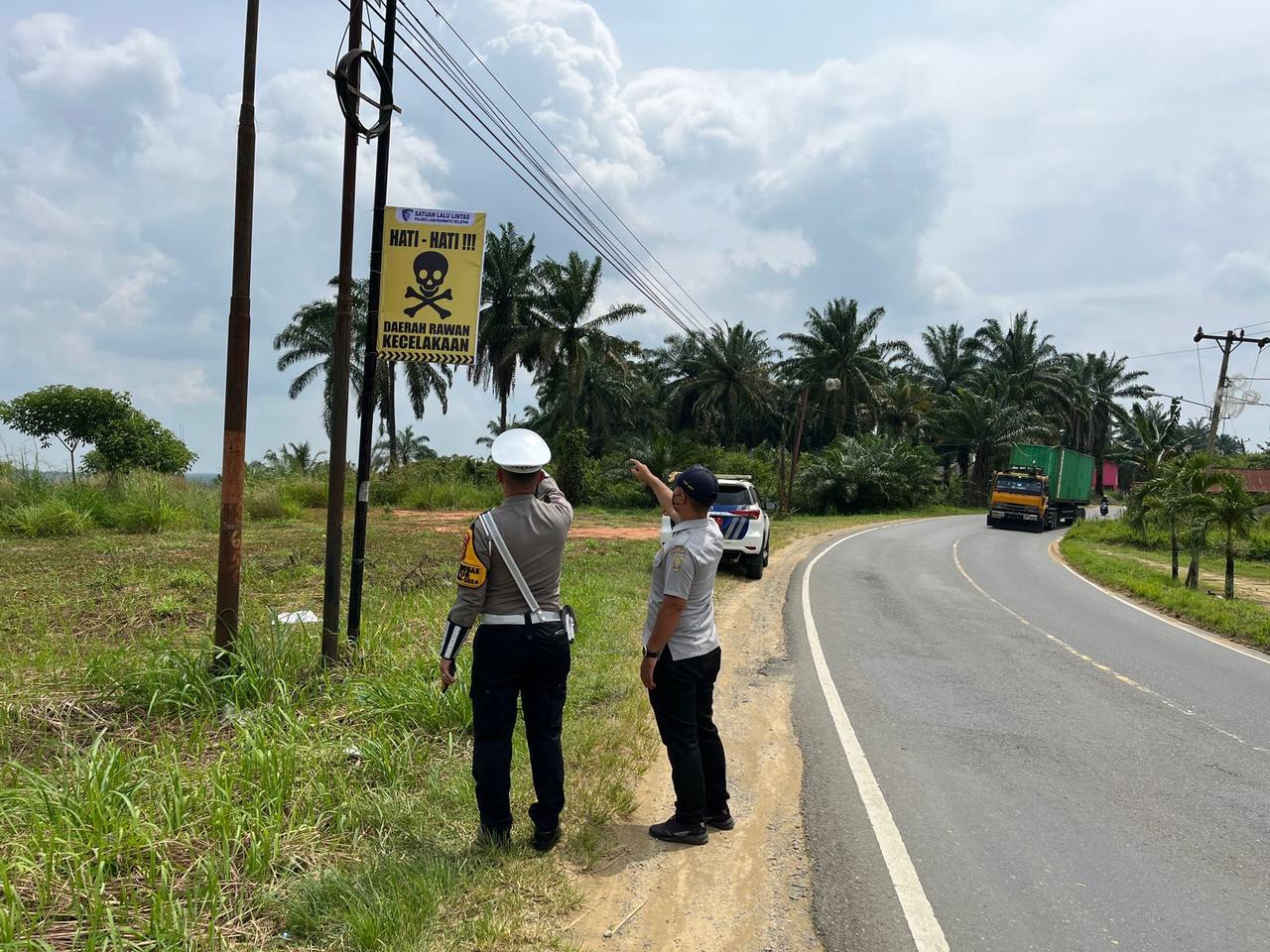 Kanit Regident Sat Lantas Polres Labusel, Ipda. M. L. Tobing saat memasang rambu peringatan di ruas Jalinsum jurusan Kotapinang-Gunung Tua, yang rawan kecelakaan lalu lintas, Jumat (14/2/2025). Waspada/Deni Daulay/